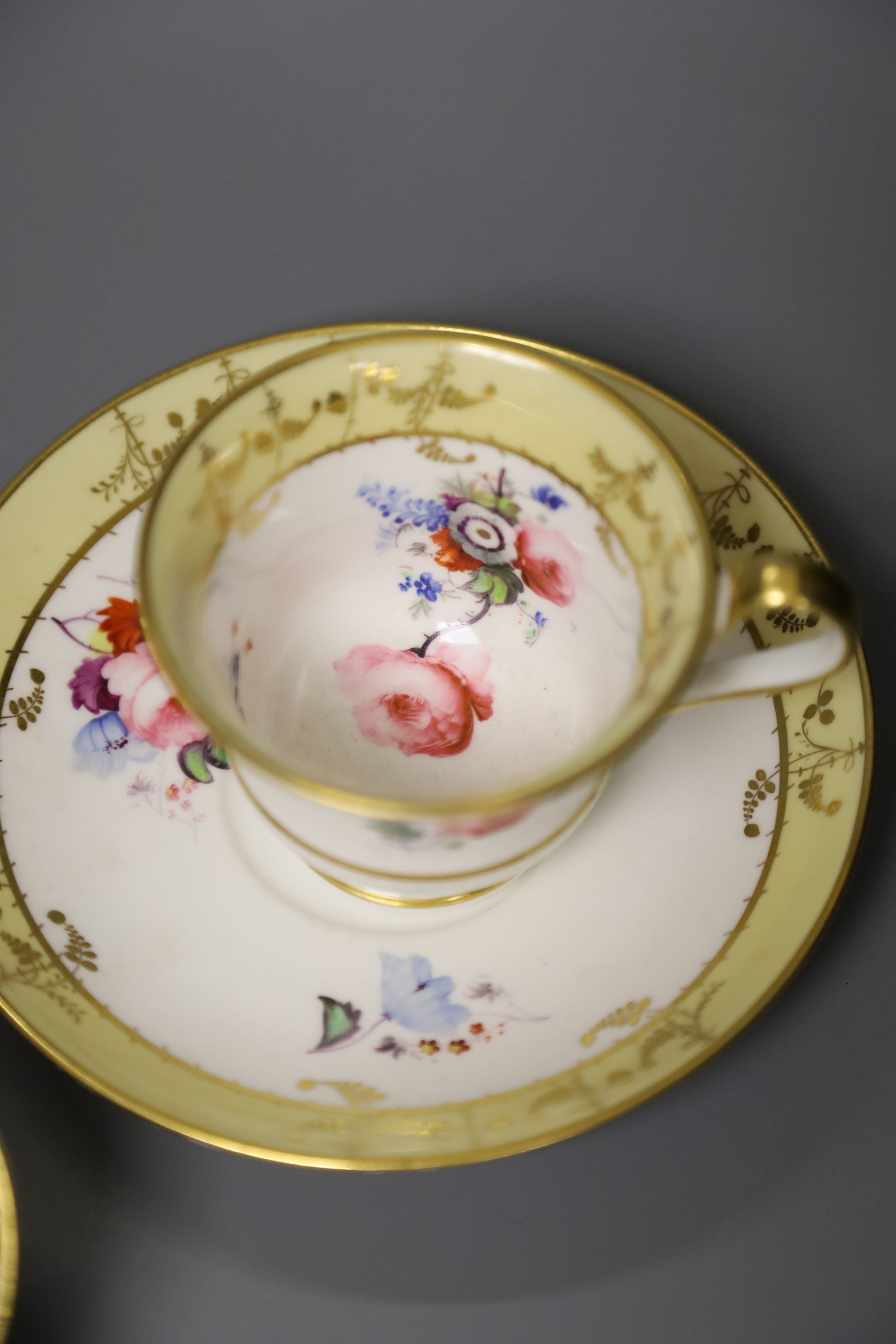 A Worcester Flight Barr teacup and saucer with gadroon border gilded with trailing berries on a salmon ground and Graingers Worcester